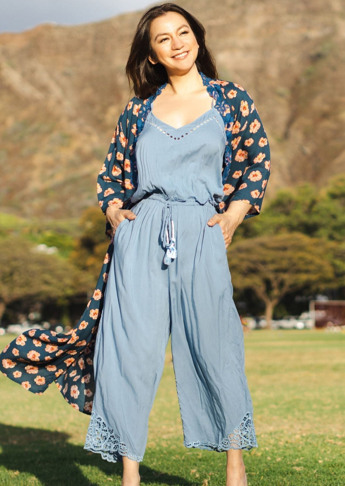 The Kiana Hawaiian Jumpsuit is one of our more popular designs. It is a romantic addition to your wardrobe. Designed with a v-neckline, tied waist, and longline silhouette, this Kiana Hawaiian Jumpsuit pairs with our exclusive feather bag.